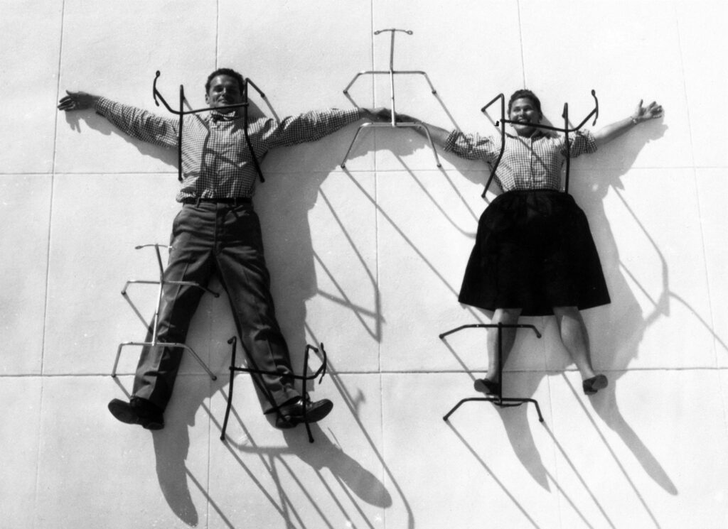 Charles und Ray Eames posieren mit Stuhlbeinen 
© Eames Office LLC.jpg