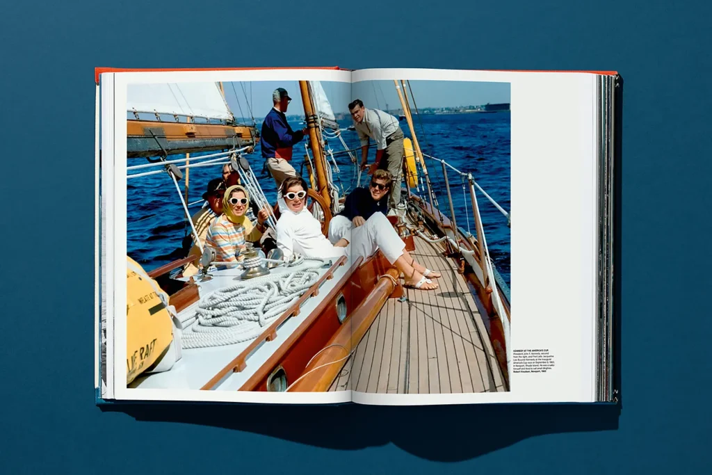 Vintage photo of elegantly dressed men and women relaxing on a wooden sailing yacht during the America’s Cup